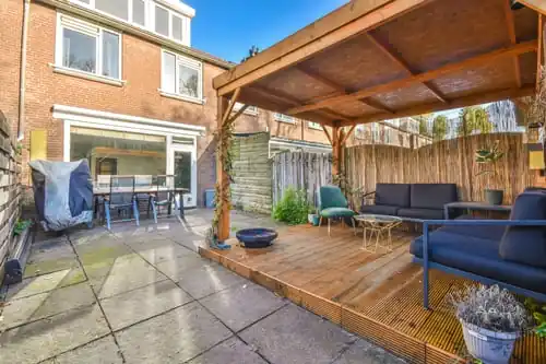 Backyard deck with a pergola and wood privacy fence
